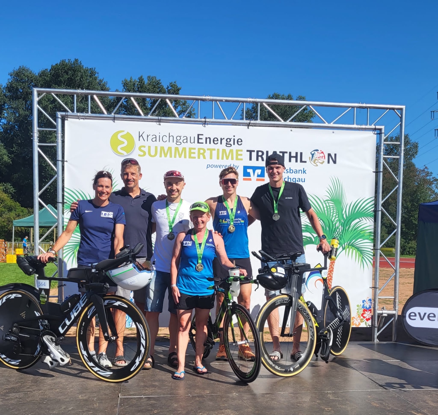 Mitglieder des Tri-Team Saarlouis mit Finisher-Medaillen und Fahrrädern beim Summertime Triathlon